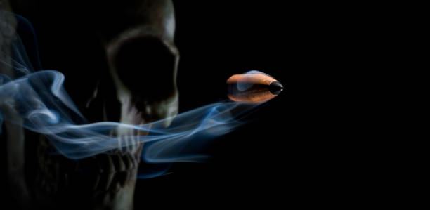 Copper bullet with smoke behind and a human skull